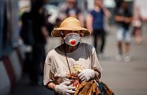 A woman wearing a face mask, walks down a street on June 21, 2021.