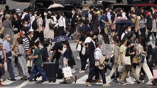 Védőmaszkos gyalogosok a japán főváros Sibuja negyedében