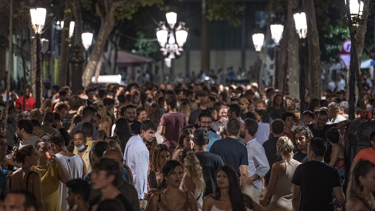 Cientos de jóvenes se reúnen en una zona de fiesta del centro de Barcelona, en el noreste de España.