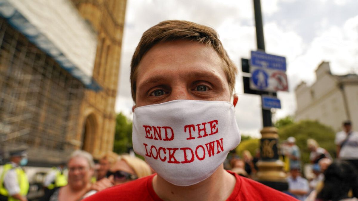 Londra'da meclis binası önünde Covid-19 kısıtlamalarını protesto eden bir kişi.