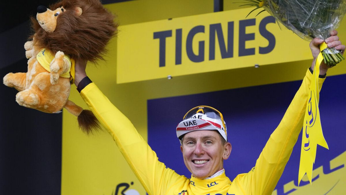Slovenia's Tadej Pogacar, wearing the overall leader's yellow jersey, celebrates on the podium after the ninth stage of the Tour de France cycling race