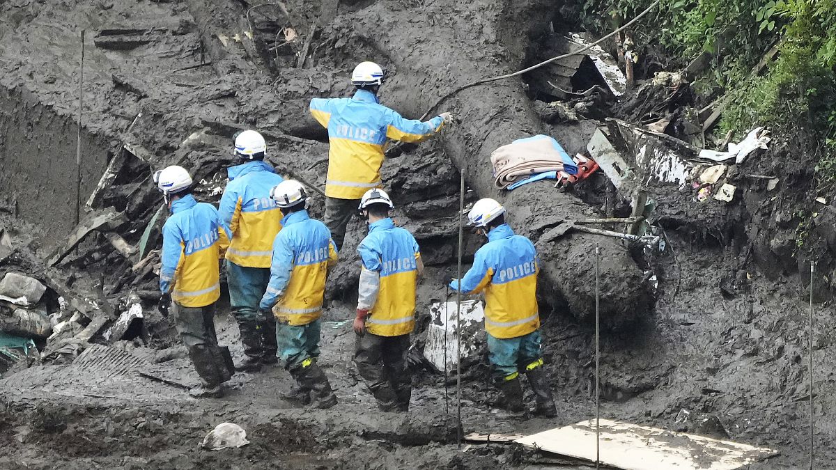 Agentes de policía buscan a través de la zona de deslizamiento de tierra causada por las fuertes lluvias en Atami, prefectura de Shizuoka, el lunes 5 de julio de 2021.
