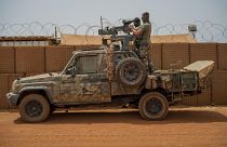 French Barkhane force commandos mount a machine gun on a camouflaged pickup as Malian workers drive by before heading on a mission from their base in Gao, Mali, June 7, 2021.