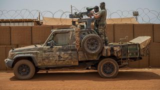 French Barkhane force commandos mount a machine gun on a camouflaged pickup as Malian workers drive by before heading on a mission from their base in Gao, Mali, June 7, 2021. 