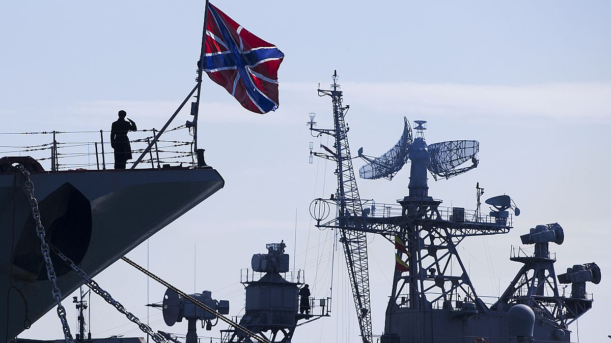 FILE: A Russian sailor salutes on the bow of Missile Cruiser Moskva, left, in Sevastopol, Crimea, Sunday, March 30, 2014. 