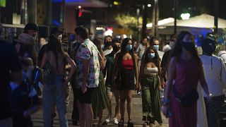 FILE: A group of people wearing face masks walk on the street In Fuengirola, near Malaga, Spain, Saturday, Aug. 8, 2020