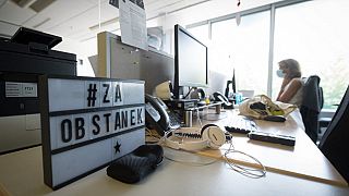 A message displayed on a table, reading “To survive”, is seen at the desk of Slovenian Press Agency (STA)