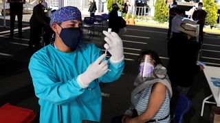 A healthcare worker prepares a dose of the Pfizer COVID-19 vaccine at a vaccination site in Peru