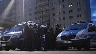 Federal German police forces stand in a parking lot in Berlin-Lichtenberg and prepare for a raid.