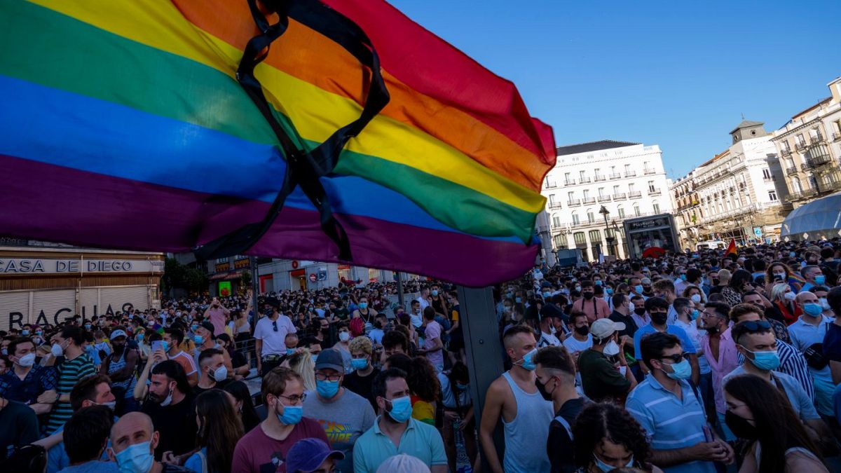 A rainbow flag with a black ribbon flutters during a protest on Monday in the Puerta del Sol in central Madrid.