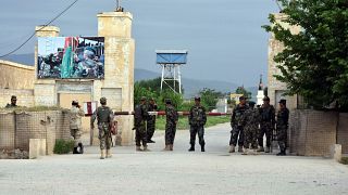 Afghan soldiers at the gate of a military compound after an attack by gunmen in Mazar-e- Sharif