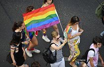 People march with a rainbow flag in Budapest