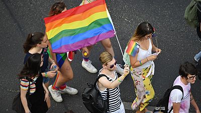 People march with a rainbow flag in Budapest 