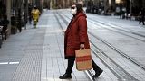 A woman crosses a normally busy street in Sydney, Wednesday, July 7, 2021