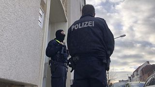 Police officers stand outside an apartment building during a search in Osnabrueck in November.