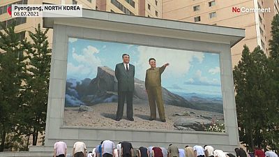 Des habitants de Pyongyang s'inclinent et déposent des fleurs devant des mosaïques à l'effigie des défunts dirigeants nord-coréens Kim Il Sung et Kim Jong Il