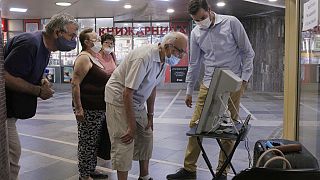 Elderly people look at a voting machine presented by Central Election Commission in Sofia