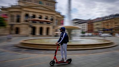 A man passes the Old Opera on an electric scooter in Frankfurt, Germany, Tuesday, June 22, 2021. A man passes the Old Opera on an electric scooter in Frankfurt, Germany, Tuesday, June 22, 2021.