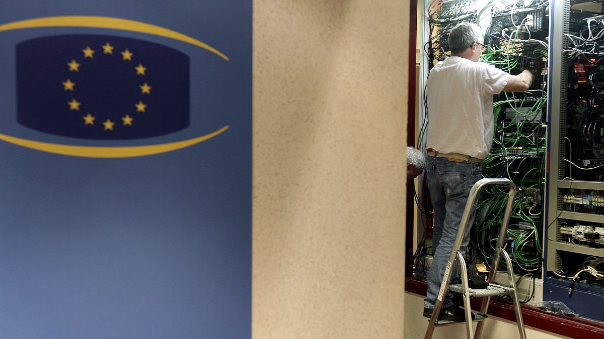 فني اتصالات يعمل في خزانة هاتف وكابل إنترنت مبنى المجلس الأوروبي في بروكسل.