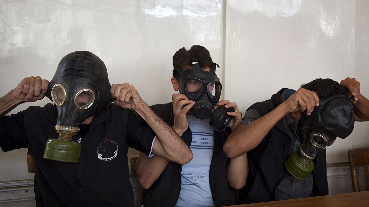 متطوعون يرتدون أقنعة واقية من الغازات خلال فصل دراسي لشرح كيفية الاحتماء من أي هجوم كيماوي، في مدينة حلب شمال سوريا في 15 سبتمبر 2013.