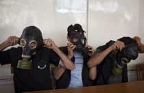 متطوعون يرتدون أقنعة واقية من الغازات خلال فصل دراسي لشرح كيفية الاحتماء من أي هجوم كيماوي، في مدينة حلب شمال سوريا في 15 سبتمبر 2013.