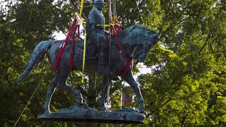 Workers remove the monument of Confederate General Robert E. Lee on Saturday, July 10, 2021 in Charlottesville, Va.
