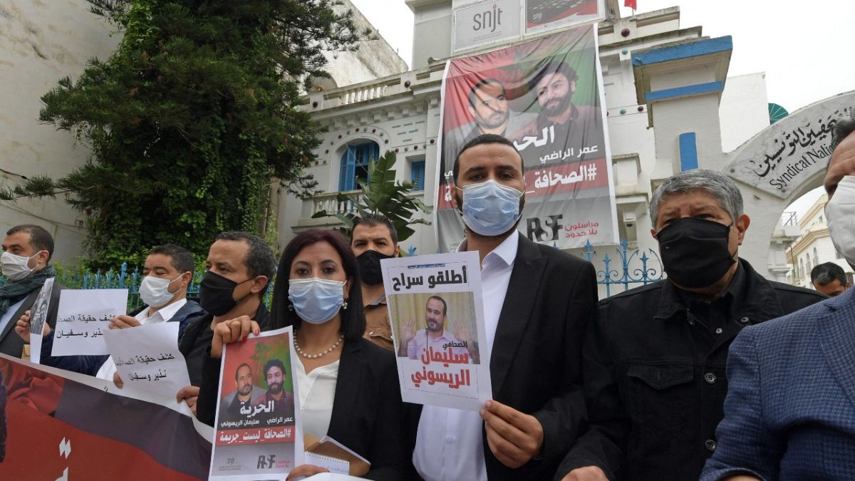  أعضاء من نقابة الصحفيين التونسيين مع ملصقات تدعم الصحفيين المغاربة المسجونين عمر الراضي وسليمان الريسوني، 3 مايو 2021