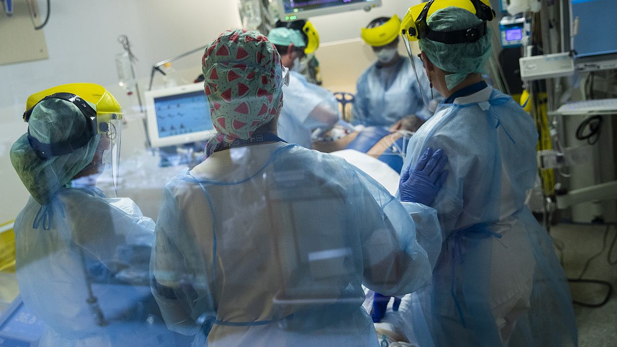 Medical staff tend to a COVID-19 patient in the intensive care ward of the Erasme hospital in Brussels, April 28, 2021.