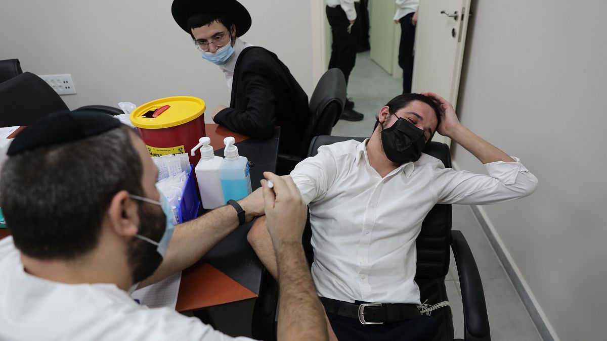 Egy zsidó férfit oltanak koronavírus ellen Bnei Brakban 2021. február 11-én