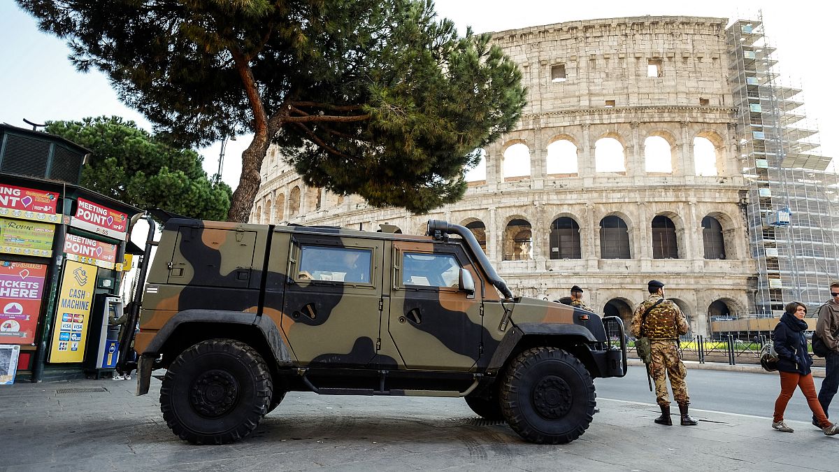 دورية من الدنود الإيطاليين تقف أمام موقع كولسيم في قلب العاصمة الإيطالية روما.