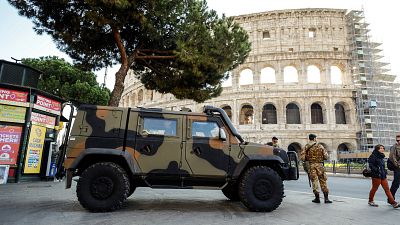 دورية من الدنود الإيطاليين تقف أمام موقع كولسيم في قلب العاصمة الإيطالية روما.