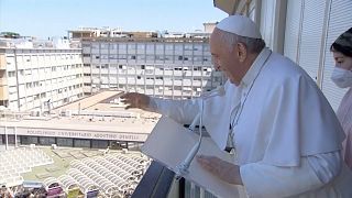 Pope Francis coming out onto balcony of hospital, faithful waving below