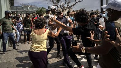 A rendőrök őrizetbe vesznek egy tüntetőt 2021. július 11-én Havannában