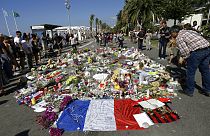 FILE - In this Monday July 18, 2016 file photo, people look at flowers placed on the Promenade des Anglais at the scene of a truck attack.