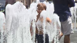 Ein Junge spielt in bis zum Anschlag aufgedrehten Wasserfontänen in Budapest