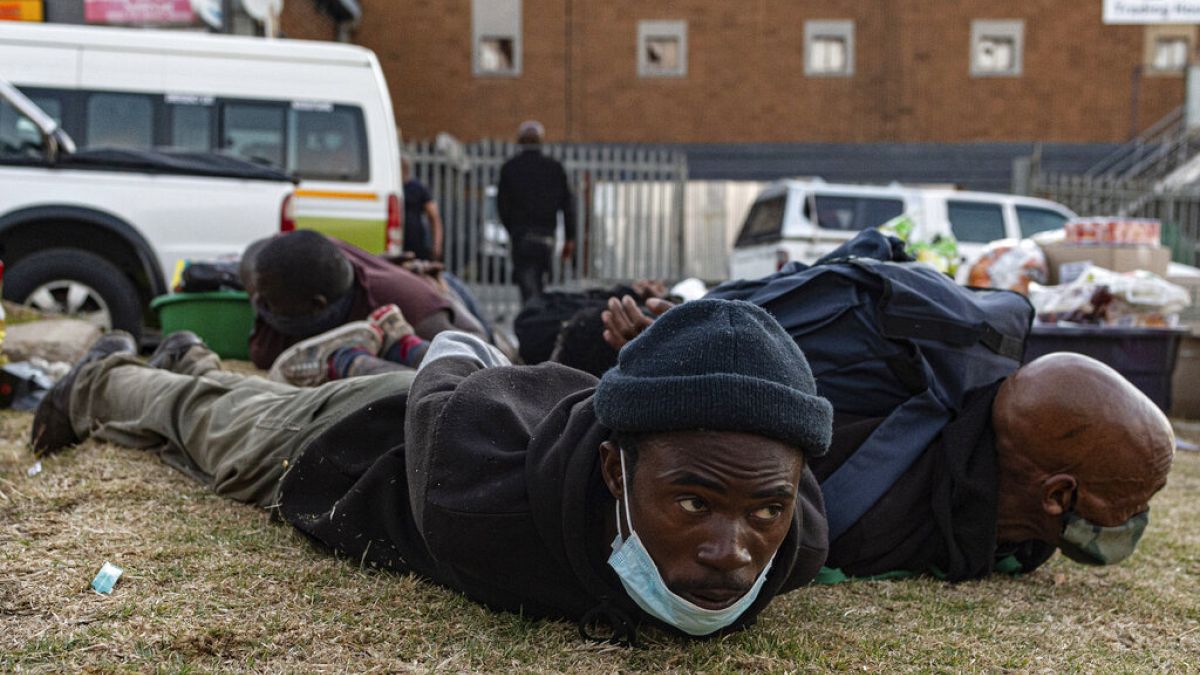 Suspect looters are held at the Bara taxi rank shops in Soweto, Johannesburg, Monday, July 12, 2021.