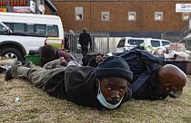 Suspect looters are held at the Bara taxi rank shops in Soweto, Johannesburg, Monday, July 12, 2021.