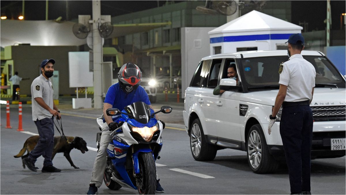 موظفو الجمارك البحرينية يفحصون سيارات المسافرين السعوديين الذين يدخلون البحرين