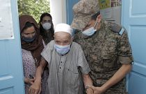 جندي تونسي يرافق عجوزاً لمساعدته في تلقي اللقاح 