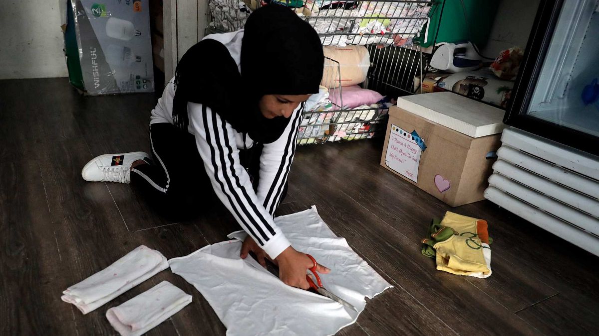 تقوم الموظفة ازدهار بإعداد الفوط الصحية في متجر خيري، تم إنشاؤه في البداية لتوزيع ملابس مجانية على المحتاجين، في العاصمة بيروت في 23 يونيو 2021