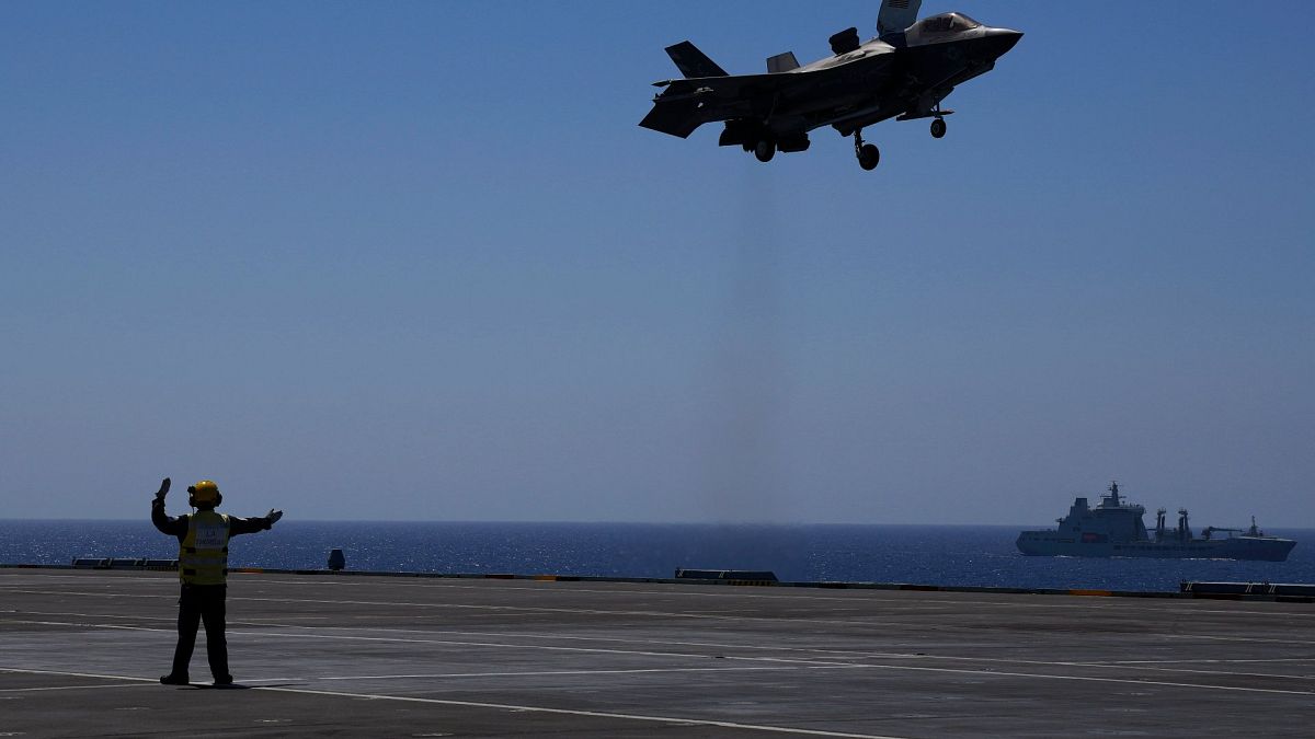 أحد أفراد الطاقم يرسل إشارة إلى طائرة أف-35 للهبوط على حاملة الطائرات البريطانية "اتش ام اس كوين اليزابيت" في البحر الأبيض المتوسط، الأحد 20 يونيو 2021