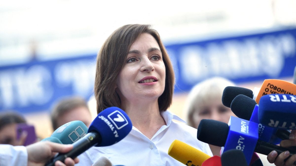 Moldovan President Maia Sandu speaks with journalists outside a polling station during parliamentary elections in Chisinau on July 11, 2021. 