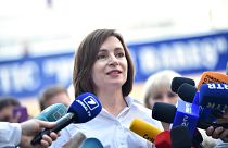 Moldovan President Maia Sandu speaks with journalists outside a polling station during parliamentary elections in Chisinau on July 11, 2021.