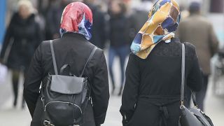 Women with head scarfs are walking in a pedestrian zone in Vienna, Austria in April 2017.