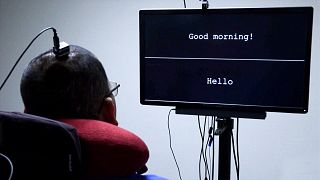 A paralysed patient looks at a screen which displays sentences that have been interpreted via a device fitted to his brain.