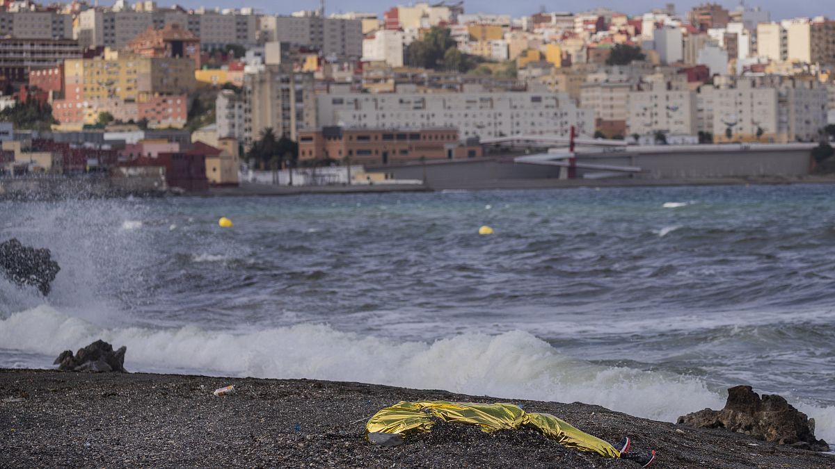 جثة شاب ملقاة على الشاطئ بعد أن انتشلها عناصر الشرطة الإسبانية من المياه المقابلة لمدينة سبتة شمال المغرب. 2021/05/20