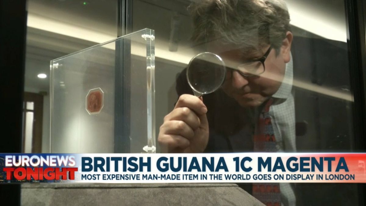 David Goldthorpe, head of books at Sotheby's, inspections the The British Guiana 1C Magenta