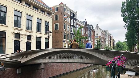 A steel 3D-printed pedestrian bridge spans a canal in the heart of the red light district in Amsterdam, Netherlands, Thursday, July 15, 2021.