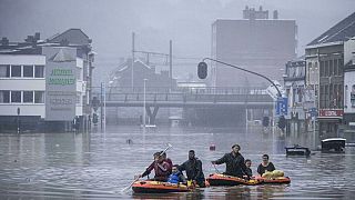 People use rubber rafts in floodwaters after the Meuse River broke its banks during heavy flooding in Liege, Belgium