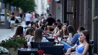 People relax after a hot day at an outdoor terrace of a restaurant in Moscow, Russia, July 14, 2021.